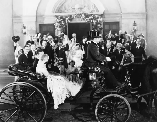 Nygifta lämnar bröllop i vagn — Stockfoto