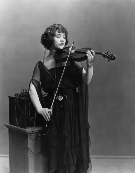 Frau spielt Geige mit Kopfhörer — Stockfoto
