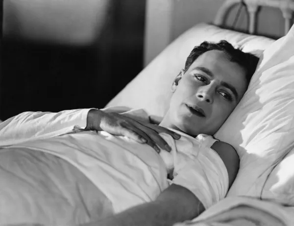 Portret van gewonde man in bed — Stockfoto