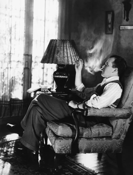 Мужчина курит в гостиной — стоковое фото