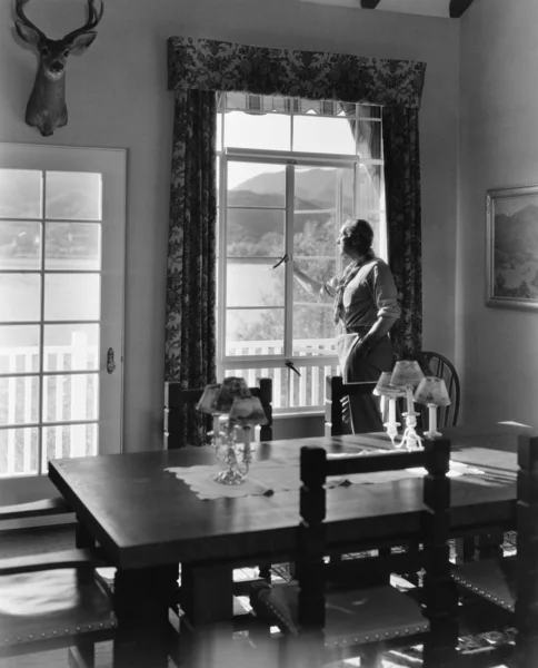 Homem de pé na janela da sala de jantar — Fotografia de Stock