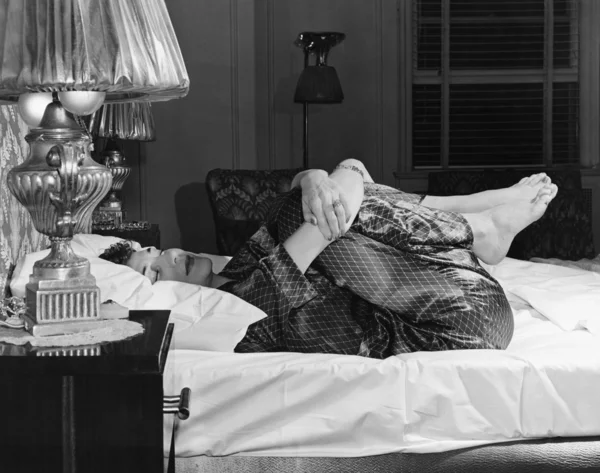 Frau dehnt sich auf Bett — Stockfoto