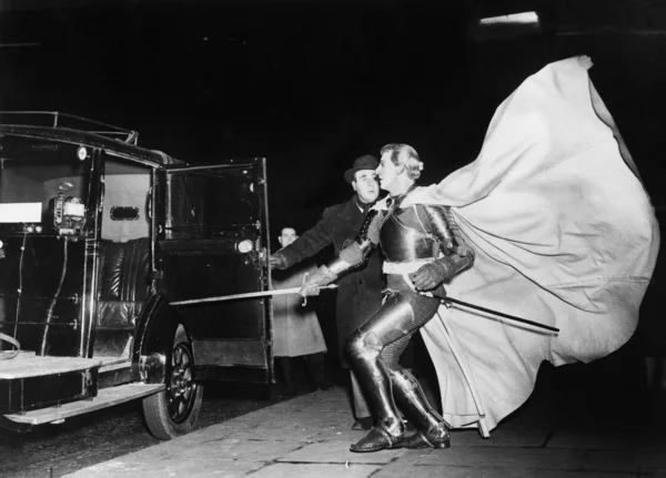 Rytíř s vlající mys blížící se auto — Stock fotografie