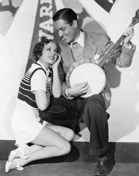 Hombre jugando banjo para adorar a la mujer — Foto de Stock