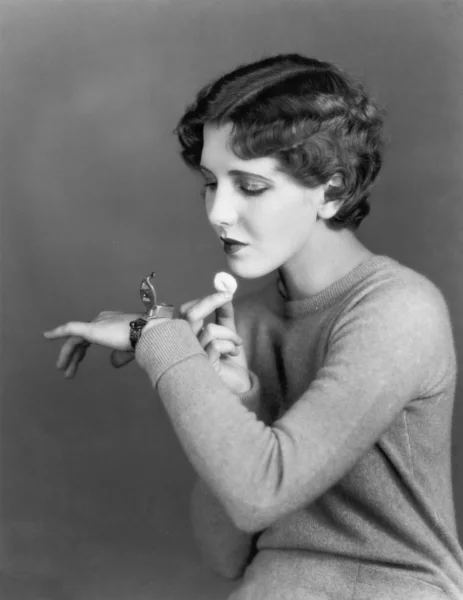 Woman using cosmetic case worn on wrist — Stock Photo, Image