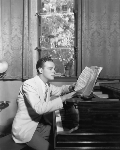 Ο άνθρωπος στο πιάνο με φύλλο μουσική — Φωτογραφία Αρχείου