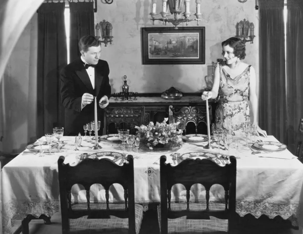 Paar zündet Kerzen auf gedecktem Tisch zum Abendessen an — Stockfoto