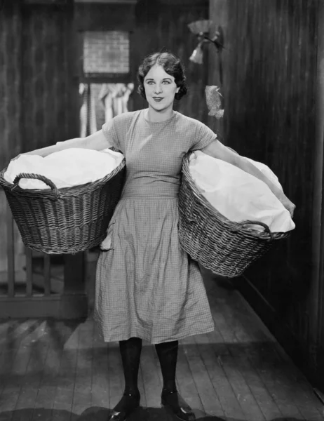 Mulher carregando cestas de roupa — Fotografia de Stock