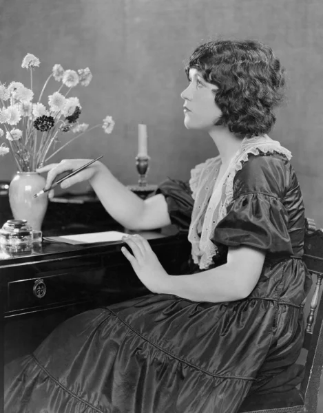 Porträt einer Frau, die am Schreibtisch schreibt — Stockfoto