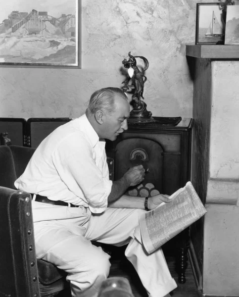 Man die luistert naar radio en krant leest — Stockfoto