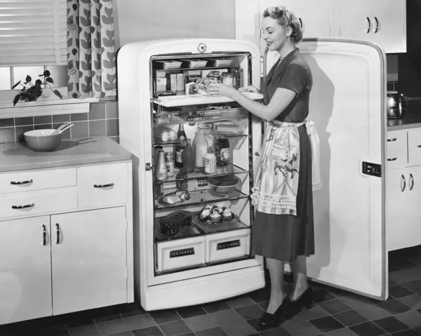 Mulher com geladeira aberta — Fotografia de Stock