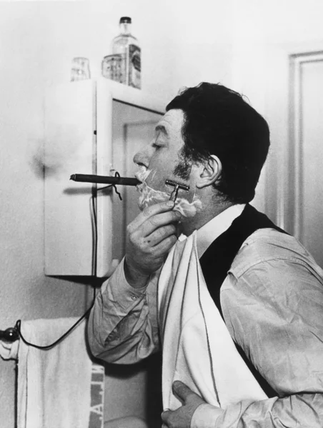 Άνθρωπος καπνίζει πούρο και ξυρίζεται — Φωτογραφία Αρχείου