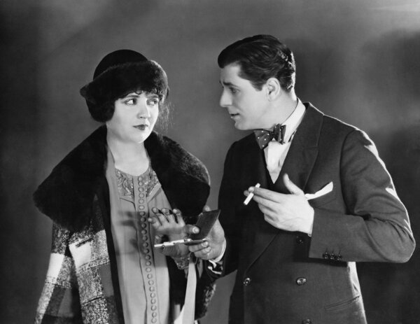 Мужчина с сигаретами разговаривает с женщиной
