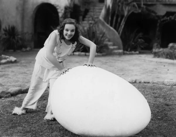 Жінка зовні з гігантським яйцем — стокове фото