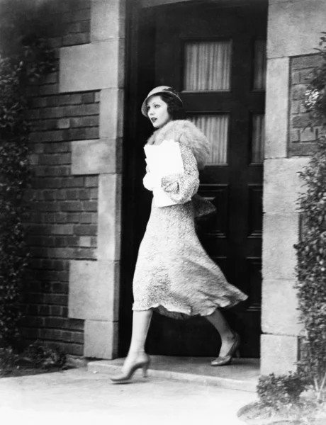 Молодая женщина выходит за дверь — стоковое фото