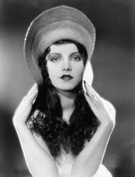 Portrét ženy ohýbání okraje klobouku — Stock fotografie
