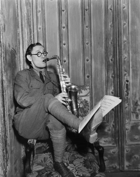 Reproductor de saxofón leyendo música a pie —  Fotos de Stock