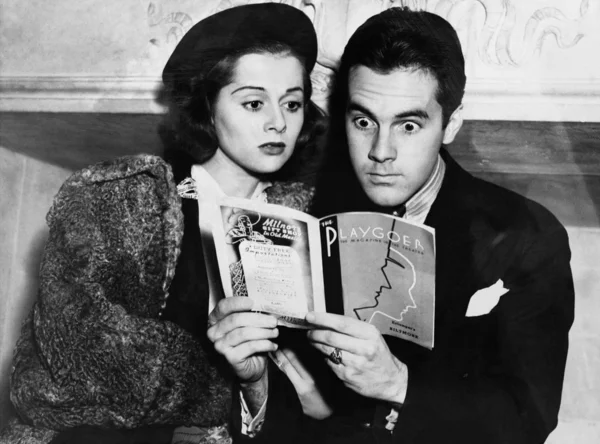 Shocked couple reading together — Stock Photo, Image