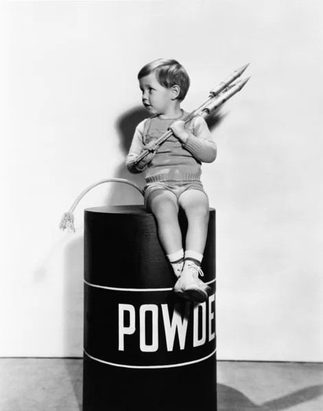 坐在火药桶上的小男孩 — 图库照片