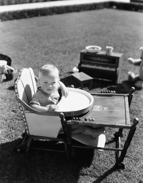 Ребенок в детском стульчике снаружи — стоковое фото