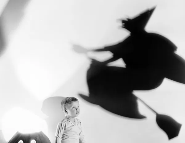 Criança com silhueta de bruxa e jack o lanterna — Fotografia de Stock