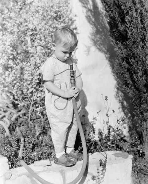 Niño señalando manguera en la cara —  Fotos de Stock