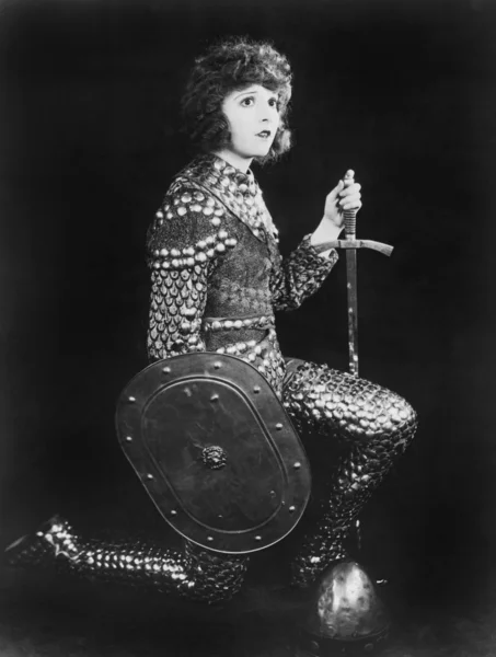 Vrouw in armor knielen — Stockfoto