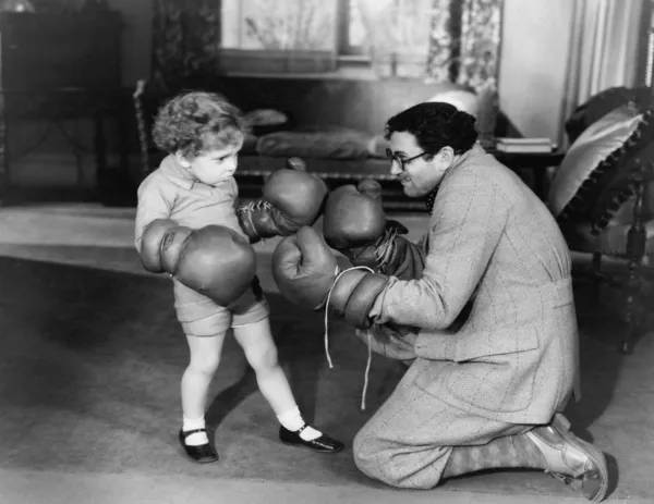 Far och unga son leker med boxhandskar — Stockfoto