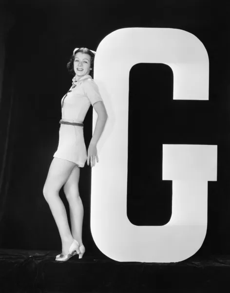 Mujer posando con enorme letra G — Foto de Stock