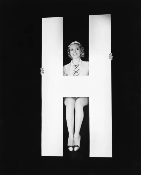 Mulher posando com enorme letra H — Fotografia de Stock