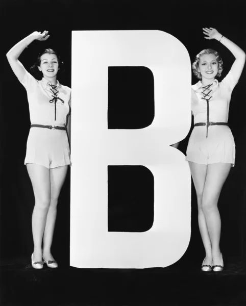 Mulheres acenando com grande letra B — Fotografia de Stock