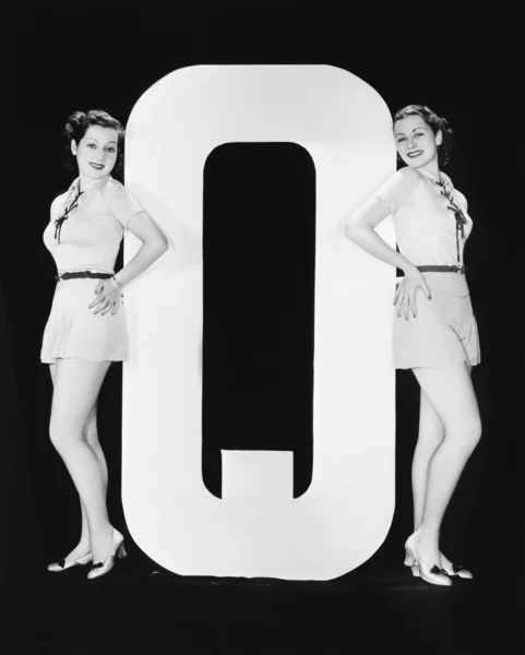Mujeres posando con enorme letra Q — Foto de Stock
