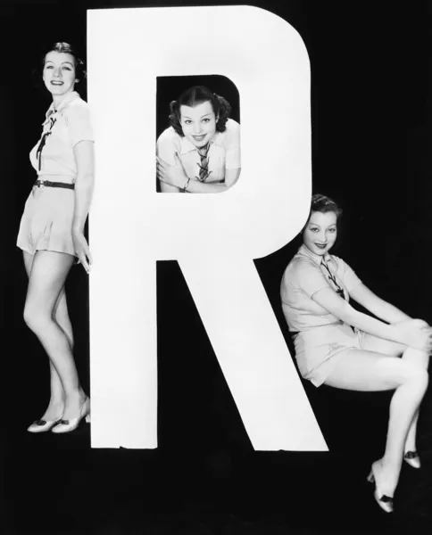 Tre kvinnor poserar med stora bokstaven r — Stockfoto