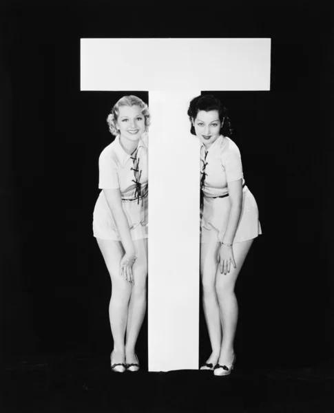 Donne in posa con enorme lettera T — Foto Stock