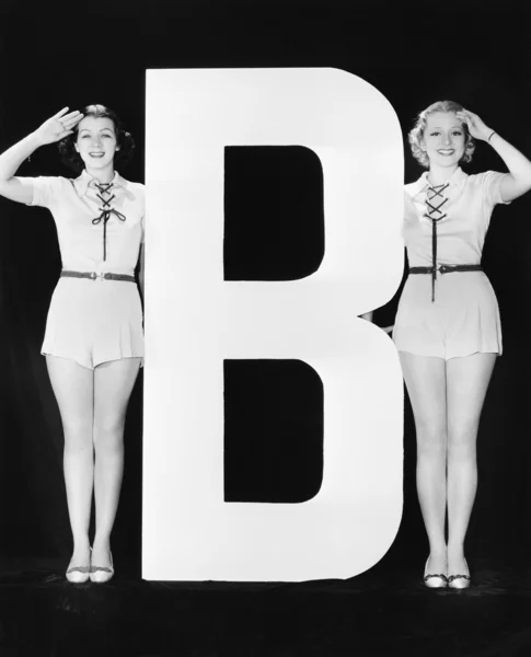 Dwie kobiety, pozdrawiając ogromne litery b — Zdjęcie stockowe
