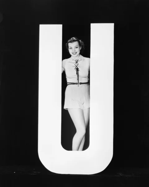Mulher posando com enorme letra U — Fotografia de Stock