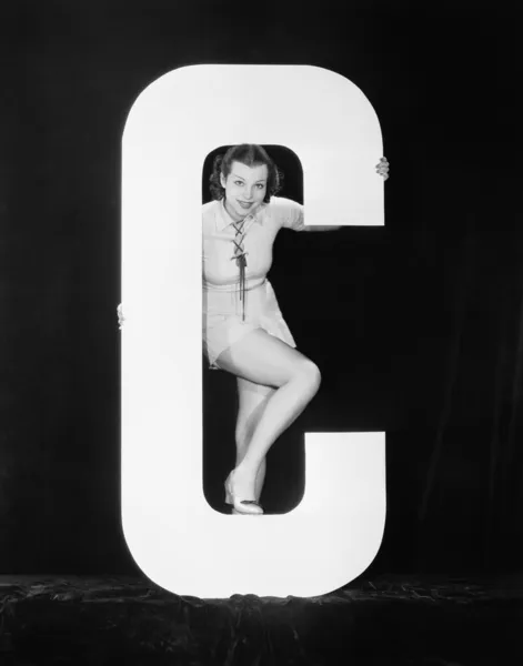 Frau posiert mit riesigem Buchstaben c — Stockfoto