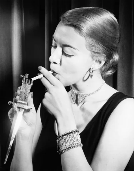 Крупный план женщины, закуривающей сигарету — стоковое фото