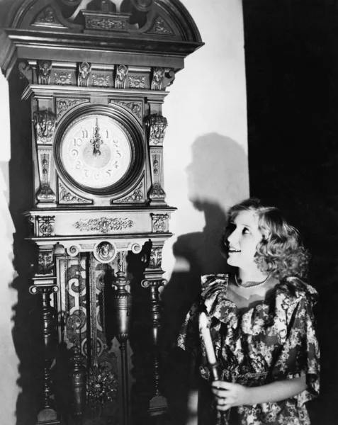 Mulher com relógio avô à meia-noite — Fotografia de Stock