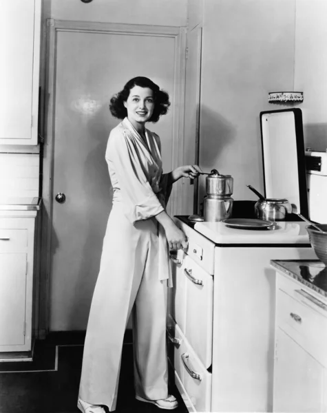 Portrait of woman at stove in kitchen — Stock Photo, Image