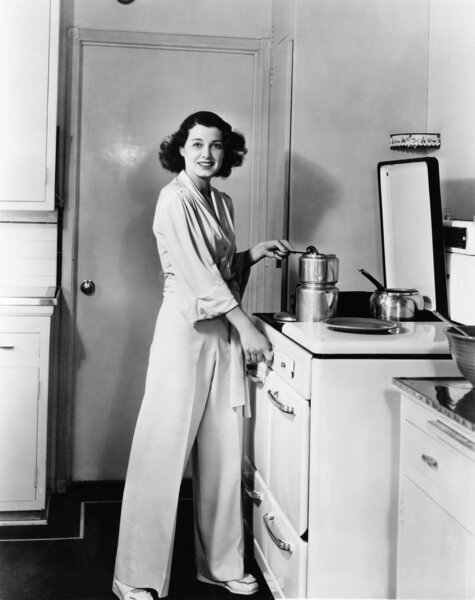 Portrait of woman at stove in kitchen