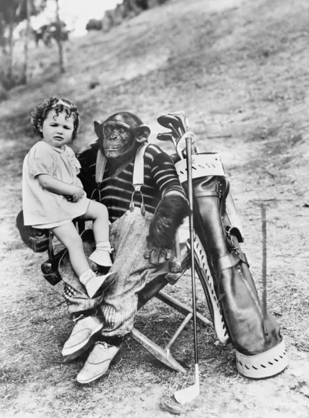 Małpa z klubów golfowych i toddler dziewczynka — Zdjęcie stockowe