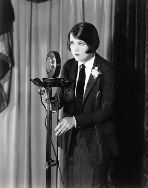 Γυναίκα στο κοστούμι στο μικρόφωνο — Φωτογραφία Αρχείου