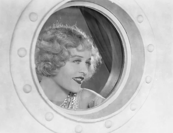 Mulher olhando através porthole — Fotografia de Stock