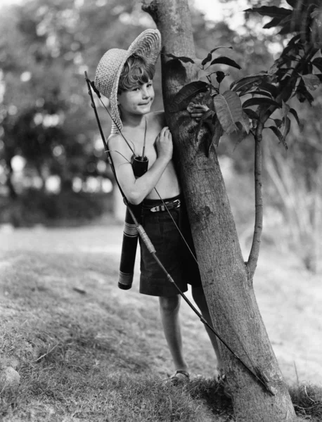Мальчик за деревом с луком и стрелами — стоковое фото