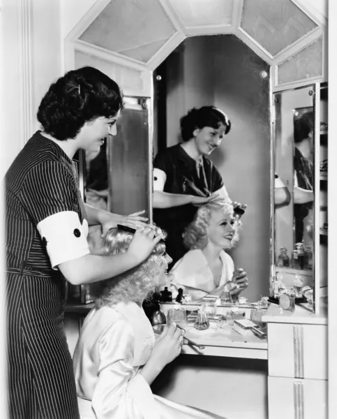 Mujer peinando otro cabello de mujer — Foto de Stock