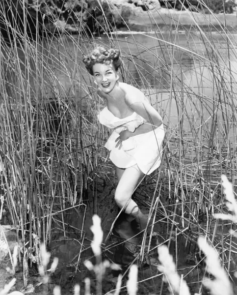 在芦苇丛中趟过的女人 — 图库照片