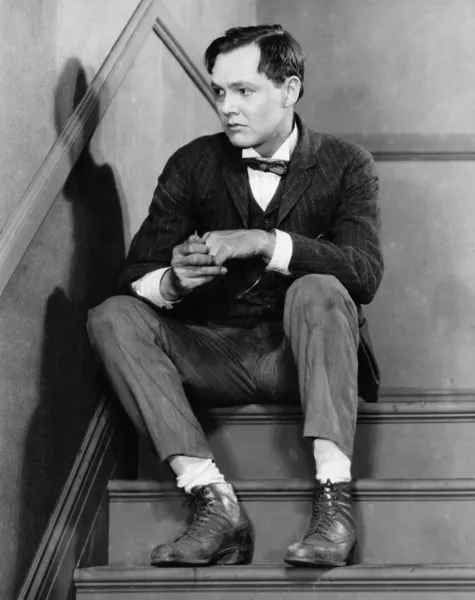 Portrét ustaraný muž seděl na schodech — Stock fotografie