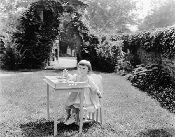 Bahçe masada yemek yürümeye başlayan çocuk — Stok fotoğraf