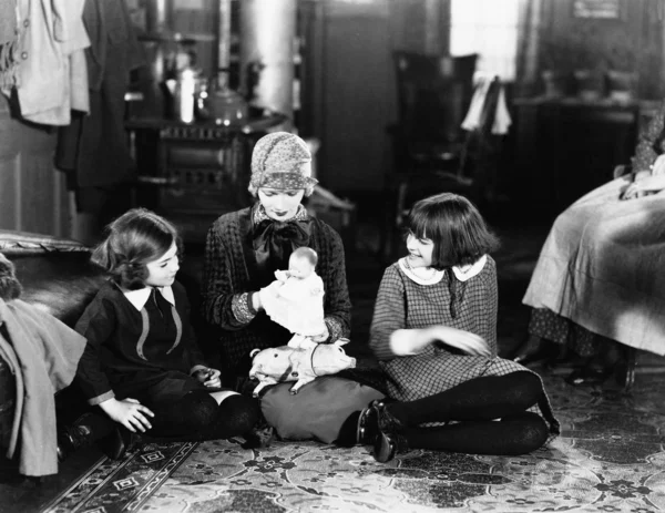 Girls and mother on floor with doll — Stock Photo, Image